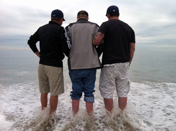 Dean Goetz, Lren Bill Kranksy and John Gomez stepping into the Pacific Ocean in California